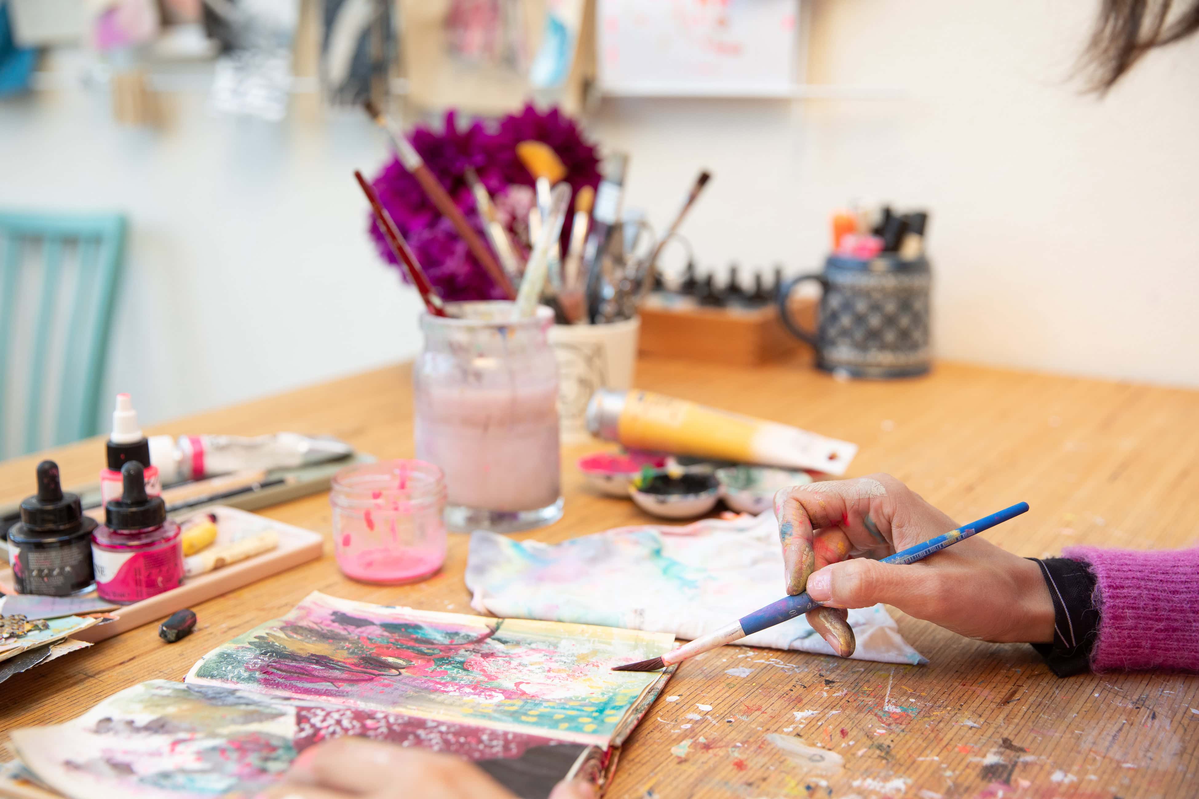 Art Journals auf einem Tisch nebeneinander, die Teilnehmerinnen bei einem Workshop gestaltet haben
