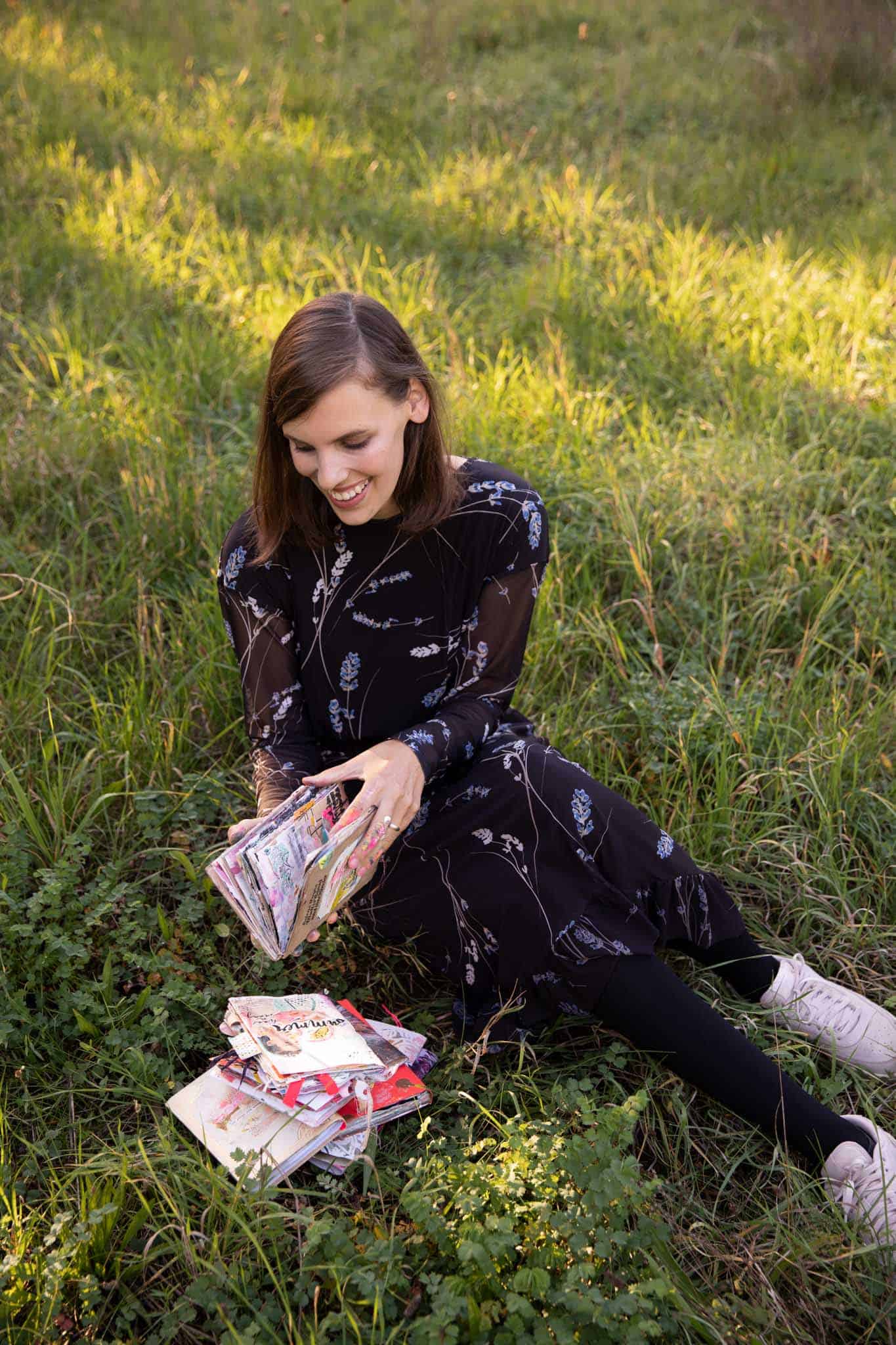 Tamara blättert auf Wiese in ihren Art Journals