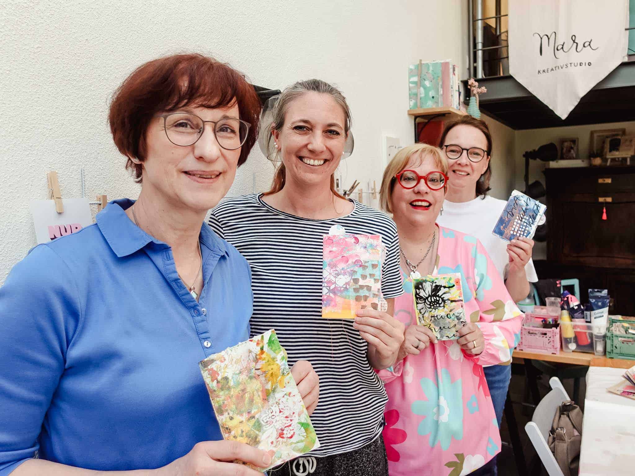Workshop Teilnehmerinnen mit Art Journals in den Händen im Mara Kreativstudio