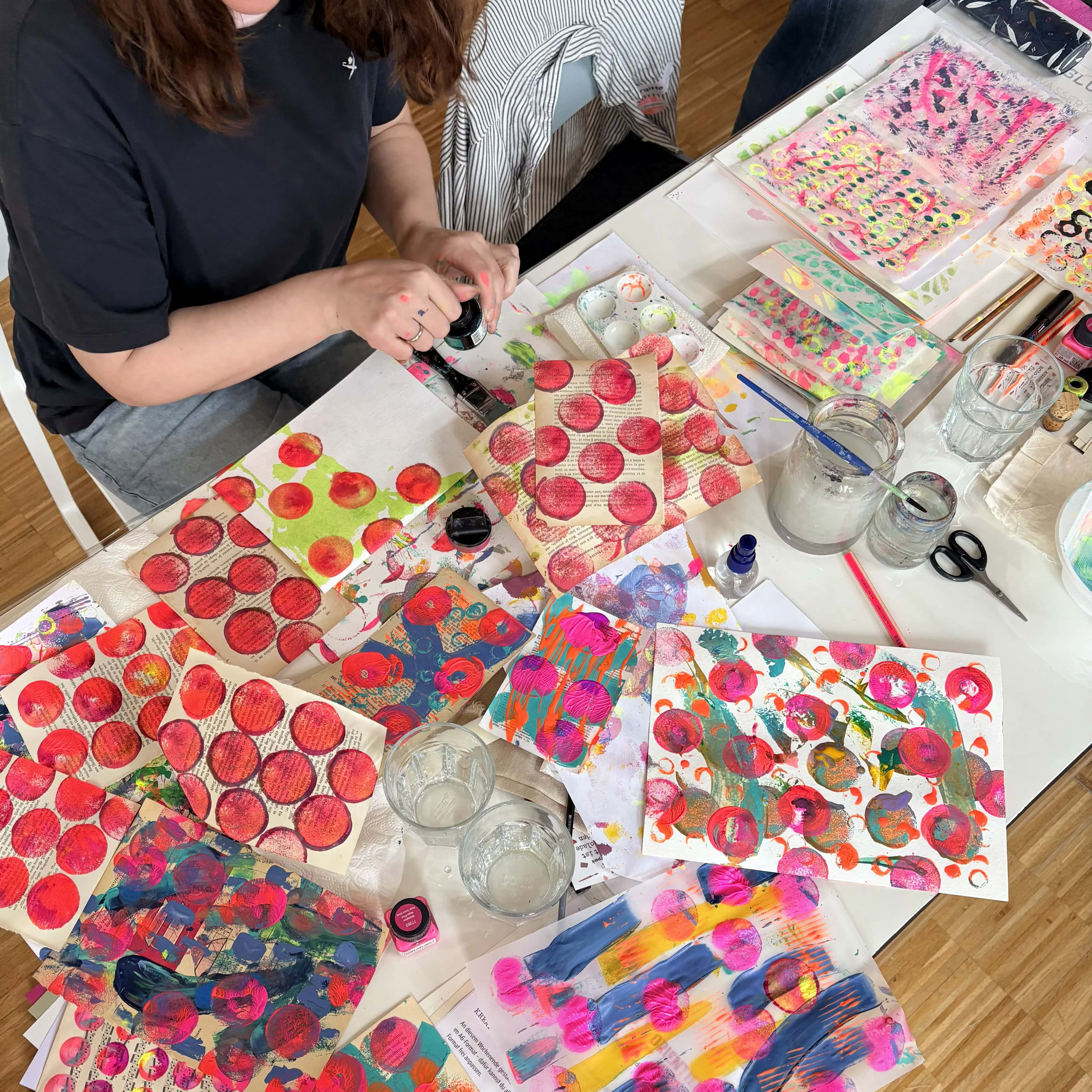 Art Journals auf einem Tisch nebeneinander, die Teilnehmerinnen bei einem Workshop gestaltet haben